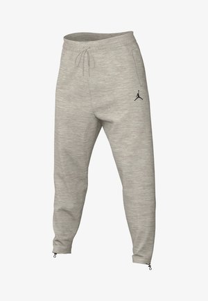 Pantalon de survêtement gris clair légèrement ajusté avec taille élastique, cordon de serrage, poches latérales, fermetures éclair aux chevilles et logo Jumpman noir sur la cuisse gauche.