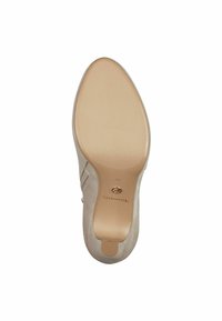 Beige korkokenkä, jossa on sileä pinta, terävä varvas ja puolimatta viimeistely. Varustettu hienovaraisella hihnalla ja pyöreällä korolla.