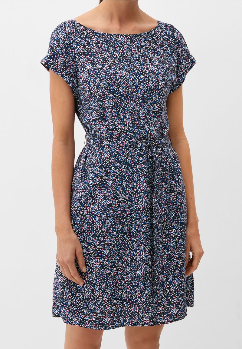 Robe imprimée florale en bleu marine, avec des manches courtes, un col rond et une taille cintrée. Le tissu est léger et d'une texture douce.