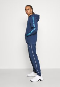 Reebok PIPING JOGGER - Calças de fato de treino - batik blue