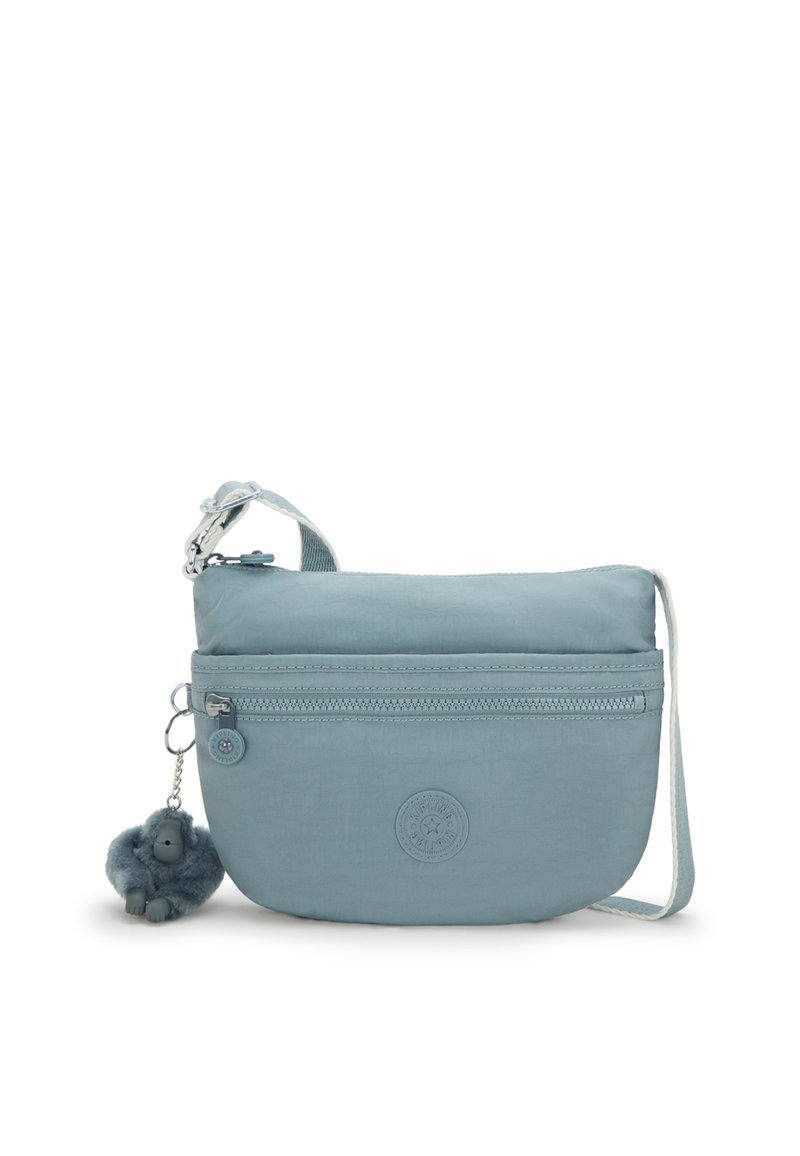 Crossbody-väska i ljusblått tyg med texturerad finish. Har en blixtlåsförsedd framficka och en fluffig ap-charm. Justerbart bälte.