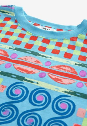 Kortærmet bomuldst-shirt i lyseblå med flerfarvede geometriske mønstre, inklusive tern, svulmende former og blomstermotiver.