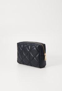 Navy quilted leather pouch with a gold zipper. Features a rectangular shape and soft texture with diamond-patterned surface.