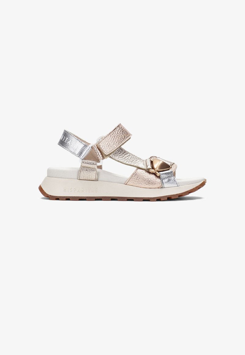 Lehká sandály se zlatými a stříbrnými metalickými pásky, nastavitelnými suchými zipy a měkkou bílou podešví s texturovanou gumovou podrážkou.