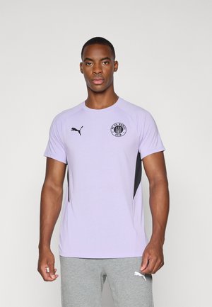 Lilla athletic skjorte med sorte accentpaneler, med rund halsudskæring og korte ærmer. Logo på venstre bryst. Blødt, let stof.