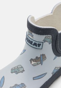 Botte de pluie en caoutchouc pour enfants de couleur bleu clair avec des motifs de véhicules et de planches de surf, élastique noir sur les côtés et intérieur rembourré pour le confort.