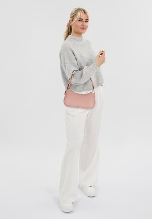 Borsa rosa chiaro con forma curva, texture morbida e tracolla regolabile, abbinata a un maglione grigio lavorato a maglia e pantaloni bianchi a gamba larga.