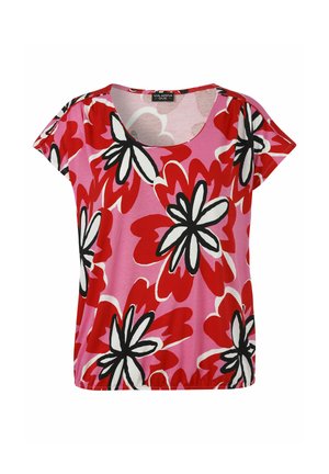 Blouse rose à manches courtes avec de grandes impressions florales rouges, blanches et noires et un col rond, présentée sur fond blanc.