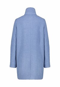 Cappotto texturizzato azzurro chiaro con colletto alto, spalle scese e design dritto; presenta una cucitura posteriore pulita e nessun hardware visibile.