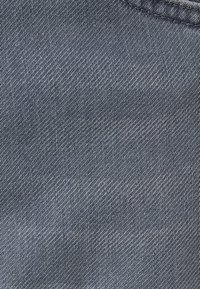 Tela gris oscuro con un fino tejido de sarga, que muestra una textura sutil. El material parece sólido sin patrones o acentos visibles.