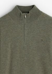 Suéter verde con cremallera y cuello alto, fabricado con tejido de punto texturizado y con un pequeño logo en el pecho. Presenta puños y dobladillo acanalados.