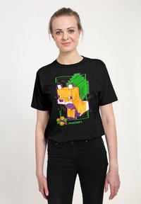 Černé bavlněné tričko s barevným motivem lišky z Minecraftu v oranžové, žluté a zelené barvě s pixelovými detaily.