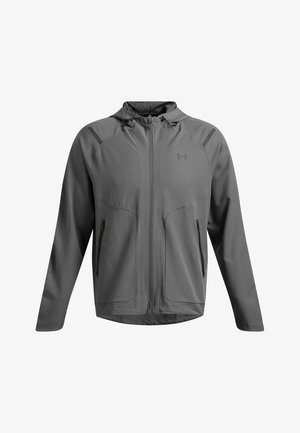 Chaqueta deportiva gris con capucha. Fabricada en un tejido ligero y suave. Cuenta con cierre frontal, dos bolsillos con cremallera y sutiles acentos en los hombros.
