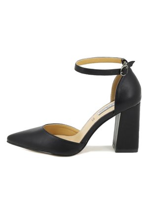 Scarpa nera con tacco alto, punta affusolata, cinturino alla caviglia e tacco spesso. Realizzata in materiale liscio con interni beige.