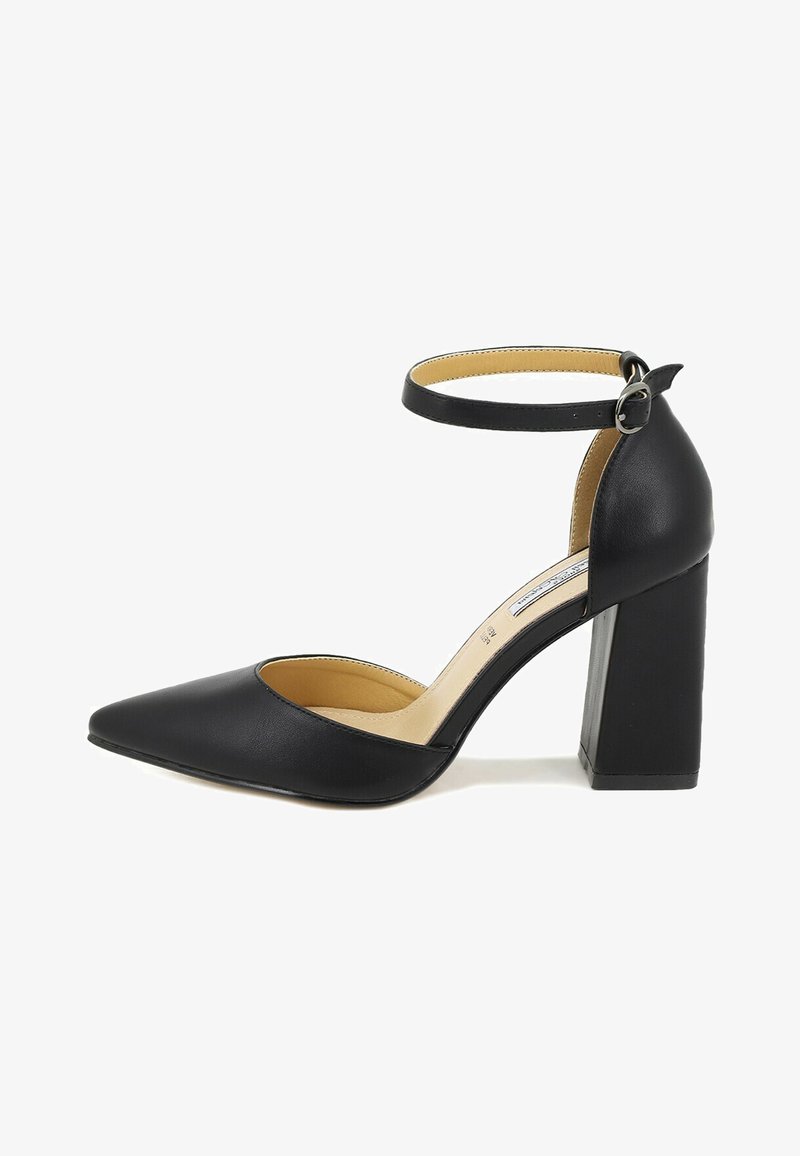 Scarpa nera con tacco alto, punta affusolata, cinturino alla caviglia e tacco spesso. Realizzata in materiale liscio con interni beige.