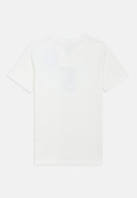 Balta kokvilnas T-krekls ar īsām piedurknēm un apaļu kakla izgriezumu. Uz muguras ir viegli redzams drukāts dizains. Mīksta tekstūra, ikdienišķa piegriezuma forma.