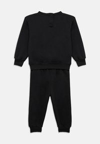 Μαύρο βαμβακερό φόρμα, που περιλαμβάνει μπλούζα με μακριά μανίκια και ριμπ μανσέτες, καθώς και παντελόνι με ελαστική μέση και στενή γραμμή.