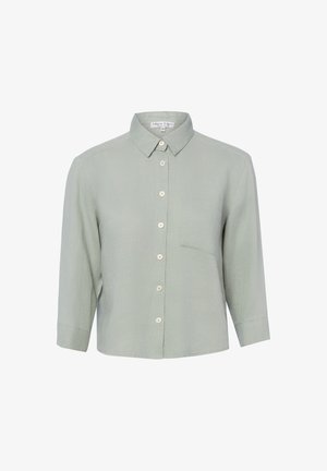 Chemise gris clair à boutons, manches longues, col pointu et poche poitrine, présentée sur un fond blanc.