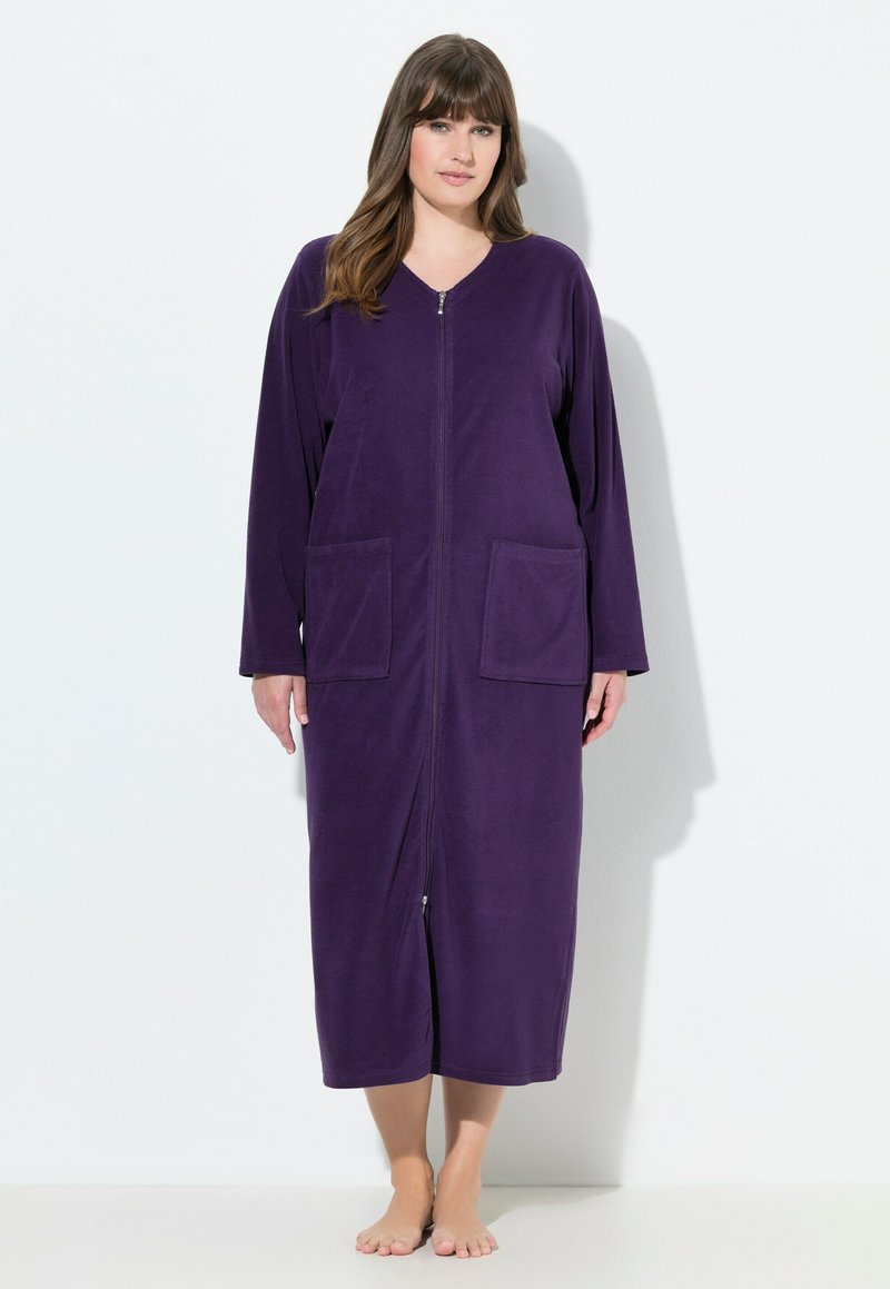 Fialový župan na zip vyrobený z měkké tkaniny, s dlouhými rukávy a dvoma předními kapsami, dosahující délky do poloviny lýtek.