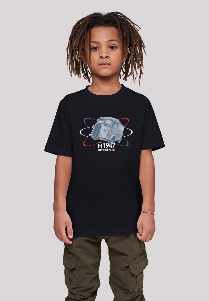 Schwarzbauchiges Baumwoll-T-Shirt mit einer Vintage-Grafik des Citroën H Vans, versehen mit "H 1947" und bunten Umlaufbahnen. Eine grüne Cargo-Hose ist sichtbar.