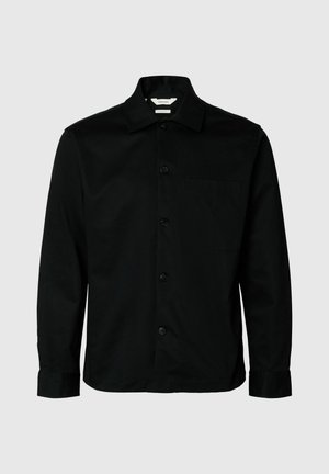 Camisa negra de botón de manga larga con cuello y bolsillo en el pecho, exhibida sobre un fondo gris claro.