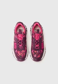 Purple and pink sneakers featuring a floral pattern on the upper, textured material, and a cushioned sole with a pull tab at the heel.
