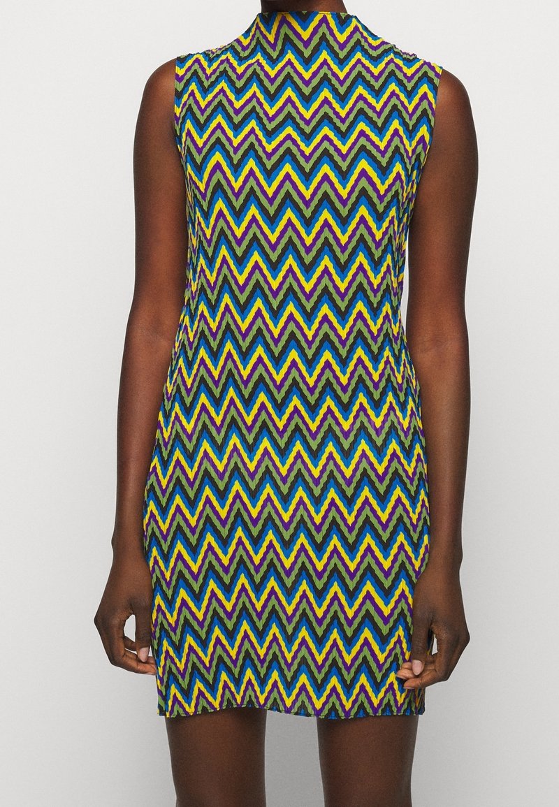 Ärmelloses Kleid mit einem Zickzackmuster in Lila, Grün, Gelb und Blau. Hoher Ausschnitt mit taillierter Silhouette und kurzer Länge.