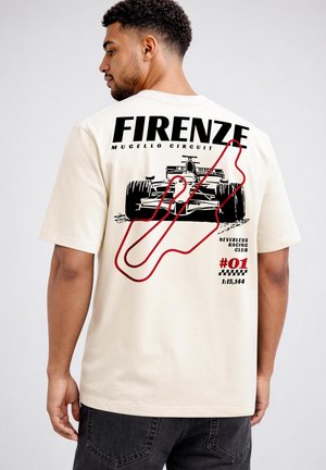 Mann trägt ein weißes T-Shirt mit einem schwarzen Rennwagen und rotem Mugello Circuit Streckenlayout sowie Text, der auf Florenz und Rennzeiten verweist.