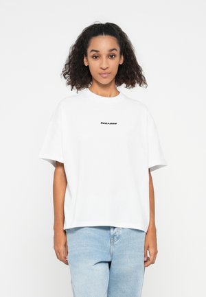 White cotton t-shirt with a relaxed fit, short sleeves, rounded neckline, featuring the word "PEGADOR" in black on the chest.