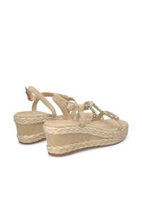 Sandali con zeppa in suede beige, piattaforma in juta intrecciata, cinturini regolabili e design frontale decorato. Texture morbida e stile aperto davanti.
