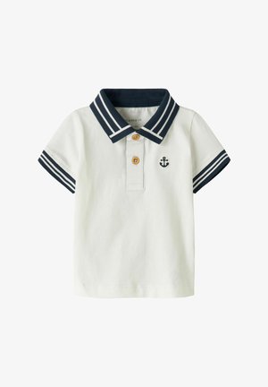 Λευκό κοντομάνικο πόλο για νήπια με κολάρο και μανσέτες ριγωτές σε ναυτικό μπλε, δύο καφέ κουμπιά και μικρό ναυτικό μπλε έμβλημα άγκυρας στο στήθος.
