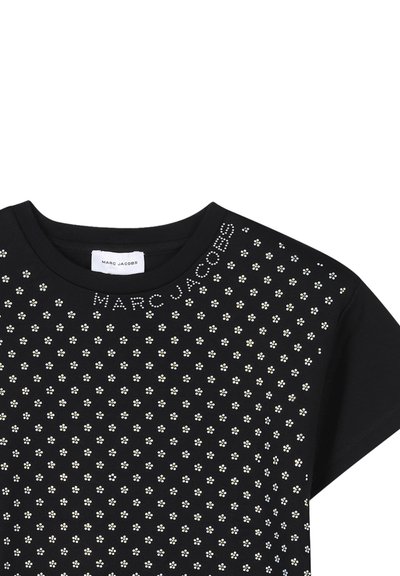 T-shirt noir à manches courtes avec des motifs floraux dispersés en blanc et des accents métalliques, avec le texte "MARC JACOBS" au-dessus de l'encolure.