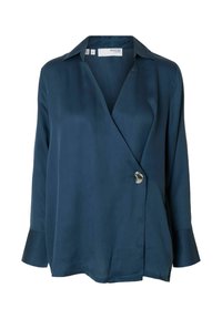 Blusa de manga larga azul marino en una tela suave con un diseño cruzado y un botón de acento plateado. Presenta un cuello clásico y mangas de campana.