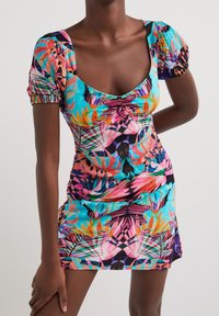 Robe à manches courtes en tissu coloré avec un imprimé de feuilles tropicales, dotée d'un décolleté carré et d'un froncé à l'avant.