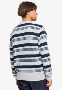 Gray pullover sweater with horizontal navy and light blue stripes, ribbed cuff and hem, knit texture, casual fit, and crew neckline.