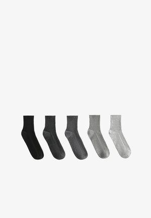 Five pairs of crew socks in black, dark gray, medium gray, light gray, and white. Ribbed texture with a seamless design.