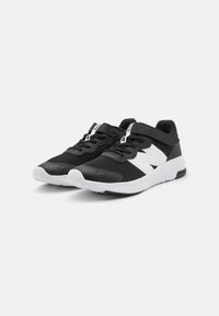 Chaussures de sport noires avec tige en mesh, embout renforcé et accents blancs. Elles disposent d'une sangle amovible et d'une semelle rembourrée pour un meilleur soutien.
