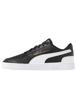 Sneaker Puma basse noir et blanc avec semelle blanche, lacets noirs, bande signature et texte doré "Ralph Sampson" sur le côté.