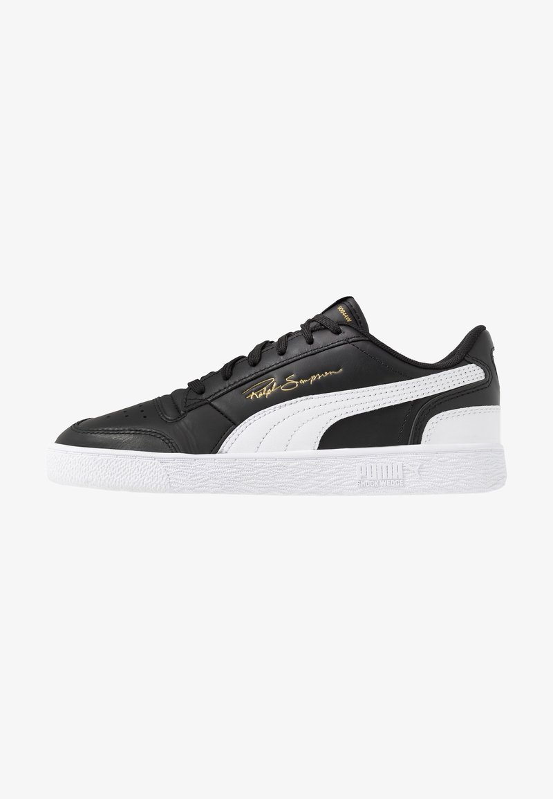 Sneaker Puma basse noir et blanc avec semelle blanche, lacets noirs, bande signature et texte doré "Ralph Sampson" sur le côté.