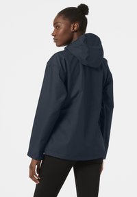 Navy blue waterproof jacket with a hood, featuring a relaxed fit and long sleeves. Smooth texture and minimalistic design with no visible logos.