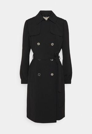 Trench-coat noir croisé avec ceinture à nouer à la taille, col pointu, manches longues et boutons argentés.