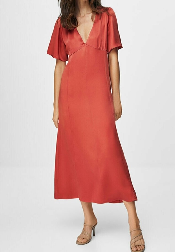 Robe maxi en satin rouge avec de courtes manches volantées et un décolleté en V plongeant. Texture lisse, silhouette fluide et longueur jusqu'aux chevilles.