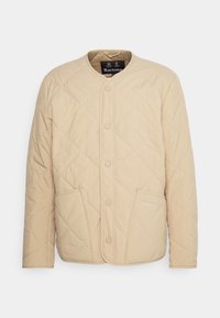 Beige gesteppte Jacke mit Rundhalsausschnitt, Frontknöpfen und zwei seitlichen Taschen. Besitzt ein dezentes Rautenmuster und eine Markenkennung auf der Tasche.
