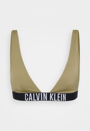Olīvu zaļš trīsstūra krūšturis ar melnu elastīgu joslu, uz kuras ir balts teksts "CALVIN KLEIN". Gluda tekstūra, minimālistisks dizains.