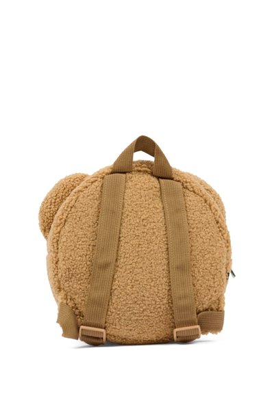 Piccolo zaino tondo in fleece teddy color beige, con spallacci marroni regolabili e una maniglia superiore, mostrato da dietro su uno sfondo bianco.