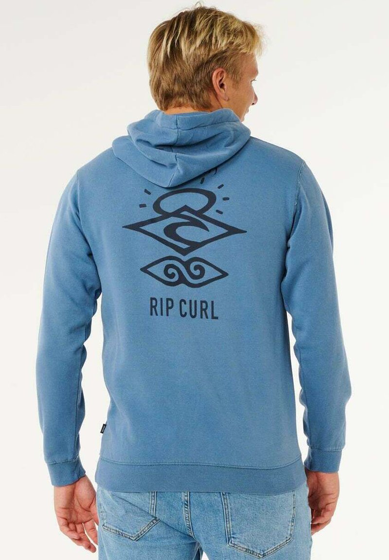 Blå hættetrøje med stort sort grafisk motiv på ryggen med bølgemønster og teksten "RIP CURL." Fremstillet af blødt materiale med en frontlomme.