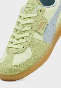 Zapatillas Puma con un esquema de color verde claro y menta, tejido texturizado y acentos de gamuza, cordones planos y suela de goma.