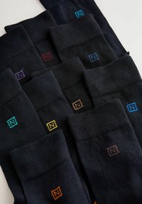 Calze nere con un design a coste e dettagli colorati variabili sui polsini. Ogni calza presenta un piccolo logo in colori differenti.