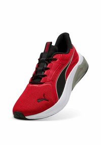 Scarpa sportiva rossa con tomaia in mesh, dettagli neri e suola bianca. Presenta collo imbottito e sistema di allacciatura, con logo Puma in evidenza.