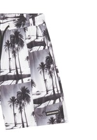 Bañadores en blanco y negro con un patrón de palmeras y playa, con cintura elástica y cordón de ajuste, marcados con una etiqueta "ANTONY MORATO".